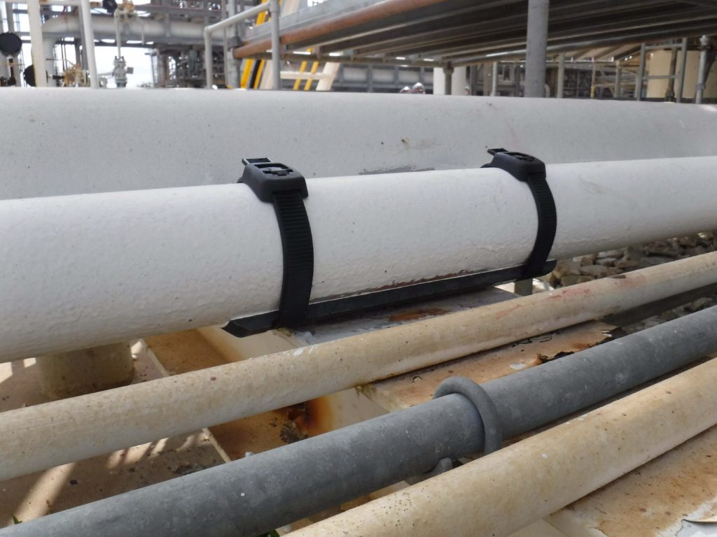 an image of five lines of pipe in a pipe rack, the second pipe from the top has a SmartPad attached and is resting on the support